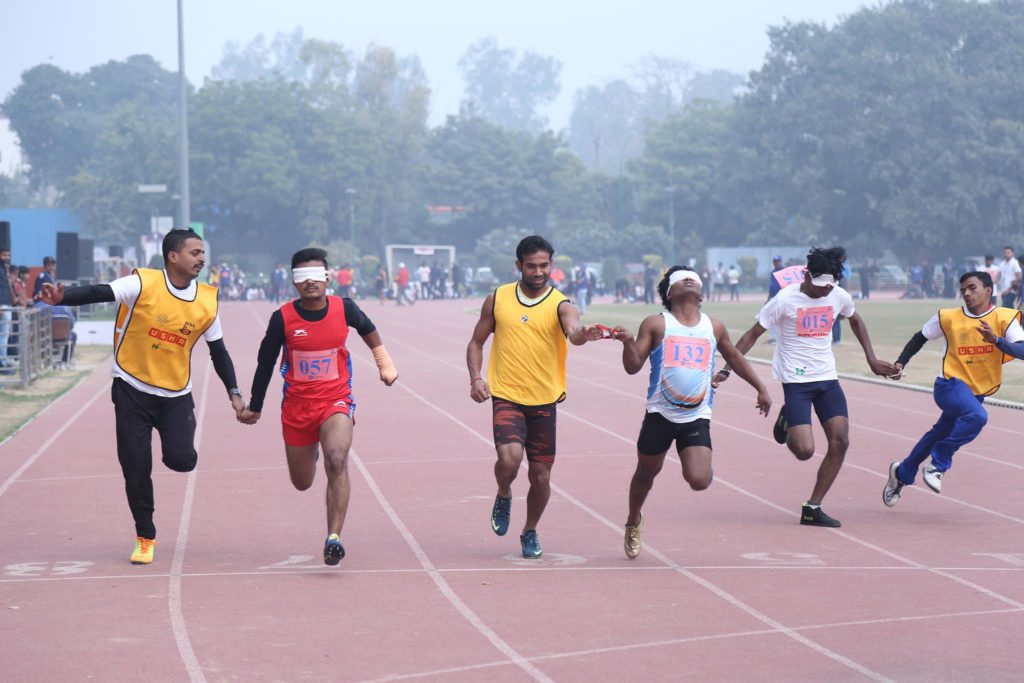 Athletes run in the 21st National Athletics Championship for the Blind along with their guide runners