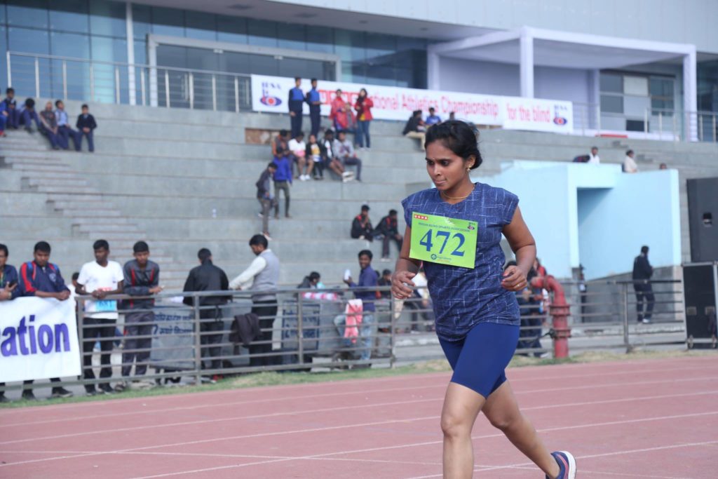 A blind female athlete running at the 21st National Athletics Championship for the Blind