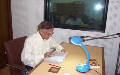 A volunteer reading books at the Recording Studio