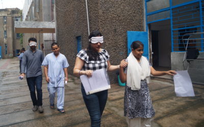 Blind trainees lead blindfolded visitors as a part of stimulation exercise