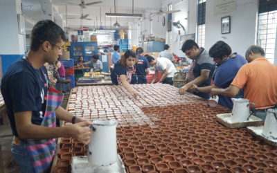 Volunteers work on diyas at the candle making section