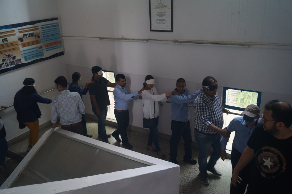 Blindfolded mentors along with visually impaired trainees playing treasure hunt